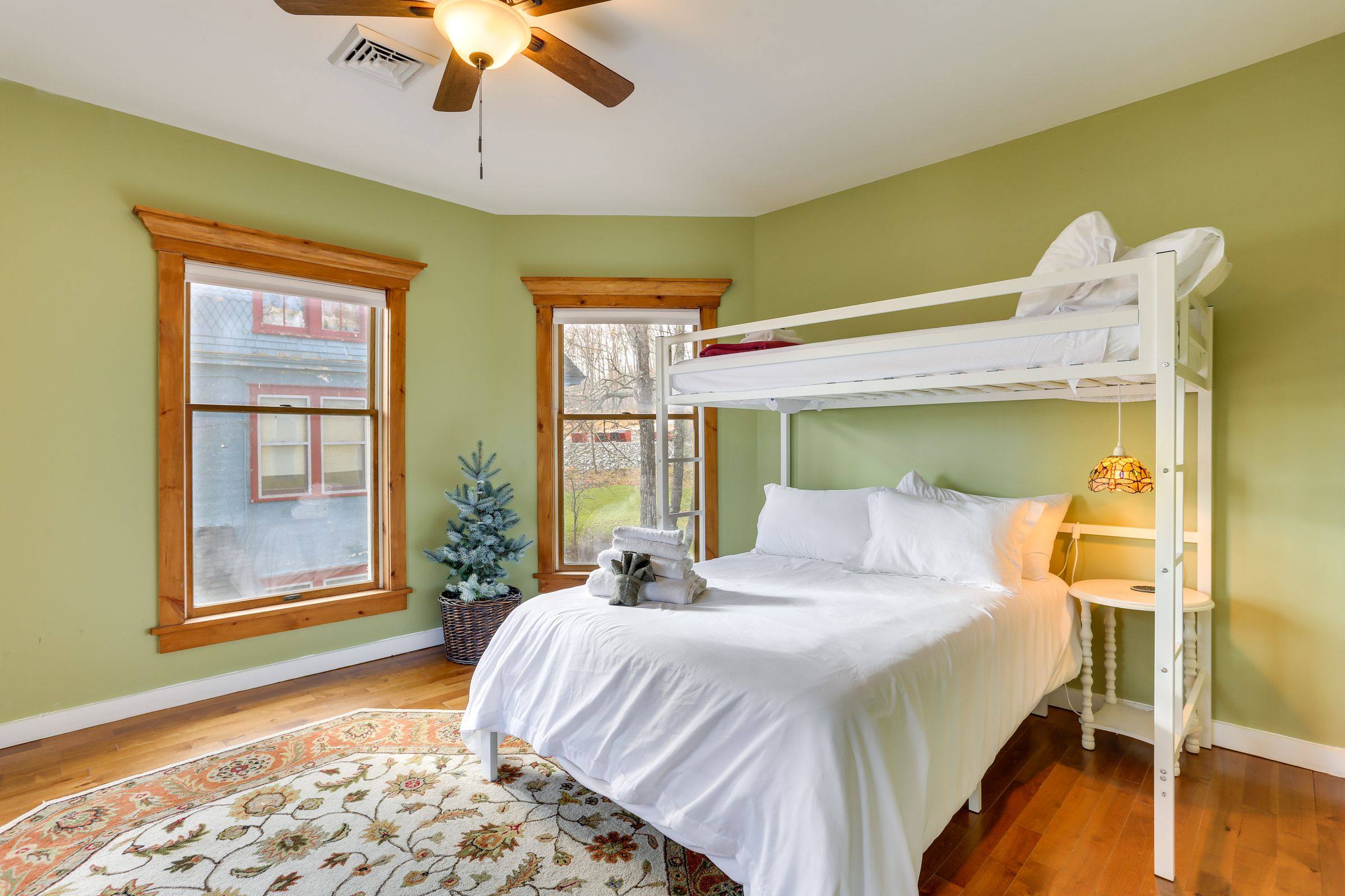 The third bedroom in soft green, with a full bed and twin bunk above it.